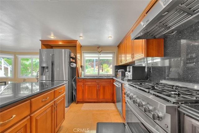 3039 Olympic View Dr, Chino Hills, CA 91709 - kitchen with stainless steel appliances, extractor fan, brown cabinets, backsplash, and dark stone countertops