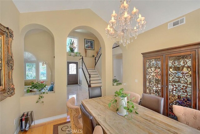 3039 Olympic View Dr, Chino Hills, CA 91709 - dining space featuring stairs, arched walkways, light wood-style floors, vaulted ceiling, and french doors