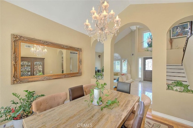 3039 Olympic View Dr, Chino Hills, CA 91709 - dining area featuring arched walkways, a chandelier, stairway, wood finished floors, and high vaulted ceiling