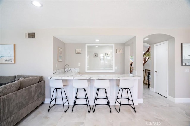 2741 Olympic View Dr, Chino Hills, CA 91709 - kitchen with a breakfast bar, a peninsula, open floor plan, recessed lighting, and arched walkways