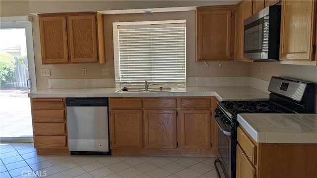 27297 Terrytown Rd, Menifee, CA 92586 - kitchen with stainless steel appliances, light tile patterned flooring, and tile counters