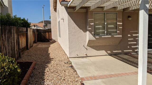 27297 Terrytown Rd, Menifee, CA 92586 - view of side of home with stucco siding and a patio