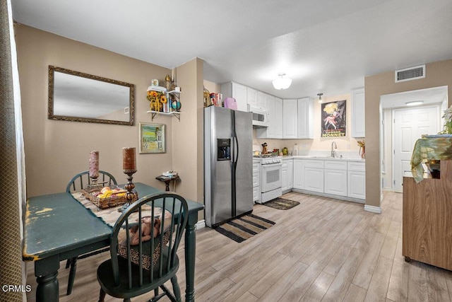 2540 El Dorado Ave Unit A, Oxnard, CA 93033 - kitchen featuring white appliances, light wood-style floors, white cabinetry, and light countertops