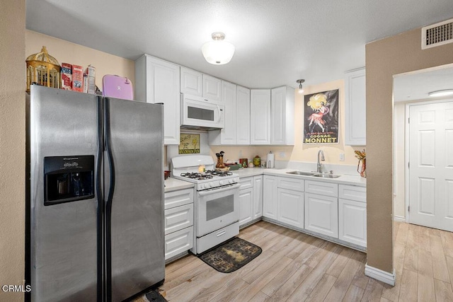 2540 El Dorado Ave Unit A, Oxnard, CA 93033 - kitchen with white appliances, light wood-style floors, white cabinetry, and light countertops