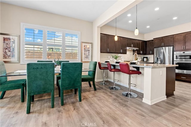 138 Listo St, Rancho Mission Viejo, CA 92694 - kitchen with stainless steel appliances, dark brown cabinets, light wood finished floors, under cabinet range hood, and recessed lighting