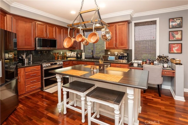 20642 Iris Canyon Rd, Riverside, CA 92508 - kitchen with stainless steel appliances, dark wood-type flooring, backsplash, ornamental molding, and brown cabinets