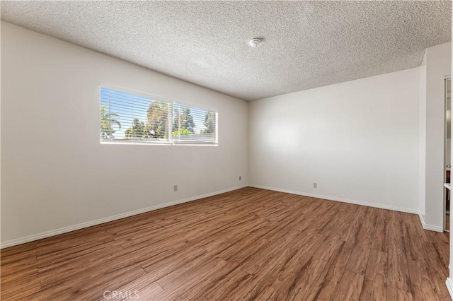 5530 Ackerfield Ave Unit 206, Long Beach, CA 90805 - unfurnished room with wood finished floors, a textured ceiling, and a smoke detector