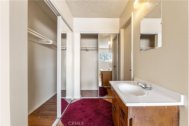 5530 Ackerfield Ave Unit 206, Long Beach, CA 90805 - bathroom featuring vanity, a textured ceiling, and wood finished floors