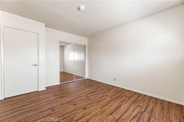 5530 Ackerfield Ave Unit 206, Long Beach, CA 90805 - unfurnished bedroom featuring wood finished floors, a closet, and a textured ceiling