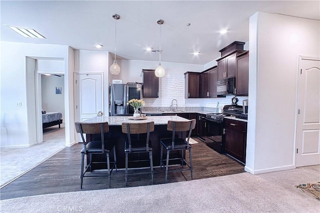 4262 Theresa Ln, Merced, CA 95348 - kitchen featuring black appliances, dark carpet, dark brown cabinetry, a breakfast bar area, and a center island