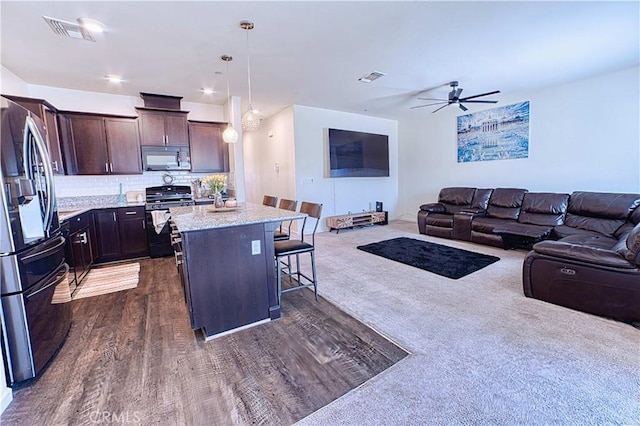 4262 Theresa Ln, Merced, CA 95348 - kitchen featuring black appliances, a kitchen breakfast bar, dark brown cabinets, ceiling fan, and open floor plan