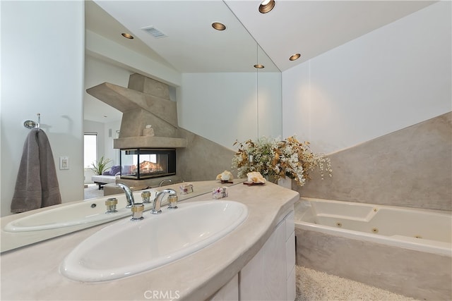 28527 Willow Rd, Lake Arrowhead, CA 92385 - full bathroom with a whirlpool tub, vanity, vaulted ceiling, recessed lighting, and a multi sided fireplace