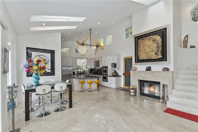 28527 Willow Rd, Lake Arrowhead, CA 92385 - living room featuring a high ceiling, stairs, a glass covered fireplace, a skylight, and recessed lighting