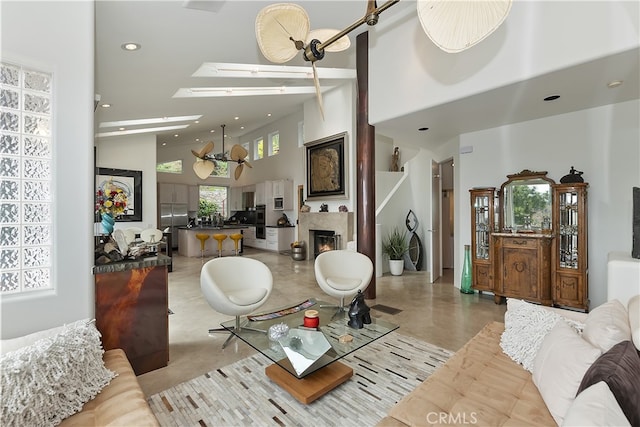 28527 Willow Rd, Lake Arrowhead, CA 92385 - living area with a high ceiling, a skylight, recessed lighting, and a warm lit fireplace