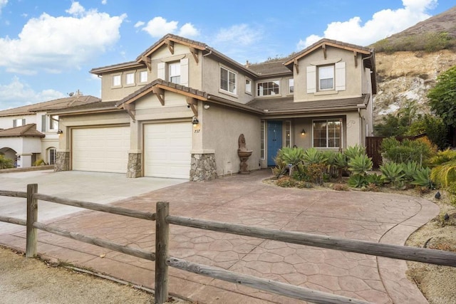 737 W Bel Esprit Cir, San Marcos, CA 92069 - view of front facade featuring driveway, stucco siding, a garage, and stone siding