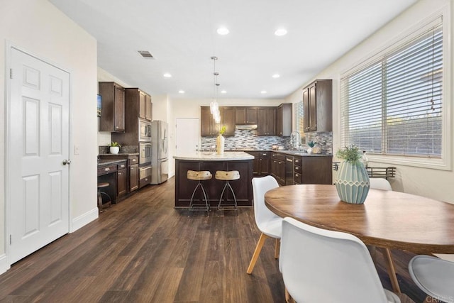 737 W Bel Esprit Cir, San Marcos, CA 92069 - kitchen with backsplash, a center island, dark brown cabinetry, dark wood-style flooring, and recessed lighting