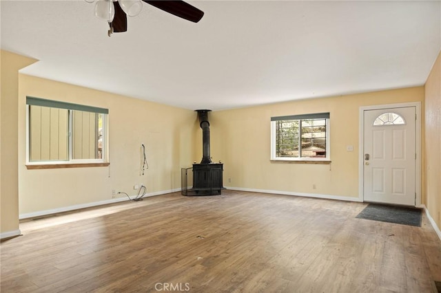 33159 Ridge Rd, Arrowbear, CA 92308 - unfurnished living room with a wood stove, ceiling fan, and wood finished floors