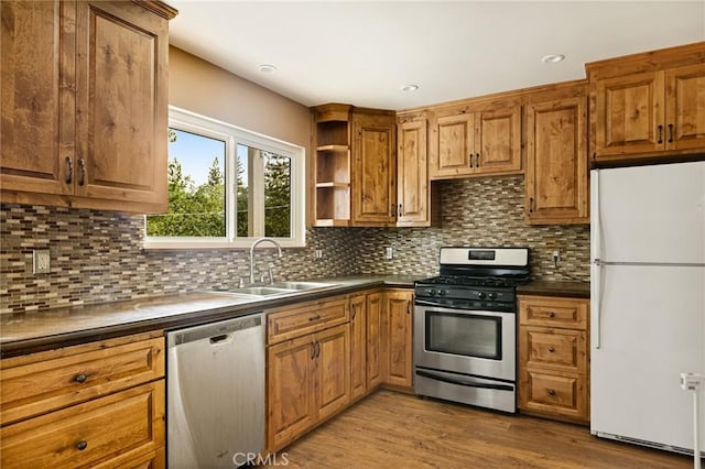33159 Ridge Rd, Arrowbear, CA 92308 - kitchen featuring appliances with stainless steel finishes, brown cabinetry, dark countertops, and tasteful backsplash