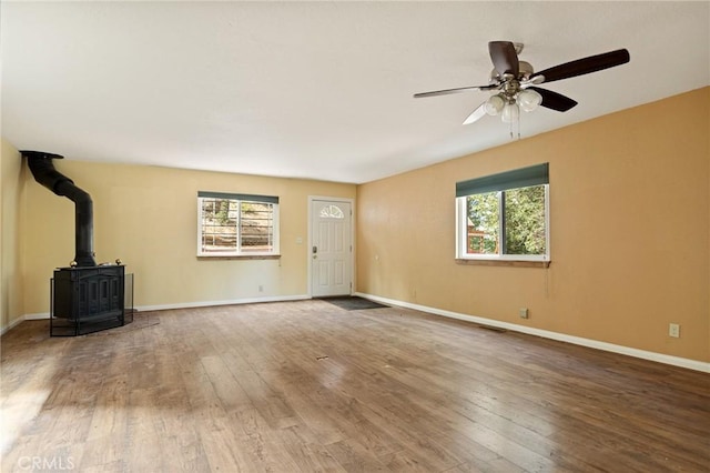 33159 Ridge Rd, Arrowbear, CA 92308 - unfurnished living room featuring a wood stove, plenty of natural light, hardwood / wood-style floors, and ceiling fan
