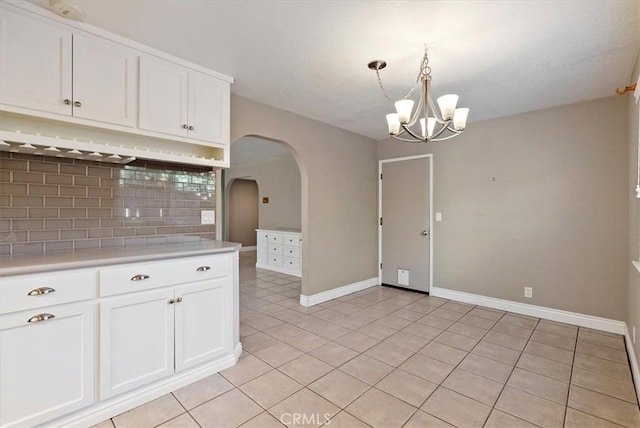836 Bolen Dr, Paso Robles, CA 93446 - kitchen featuring tasteful backsplash, light countertops, arched walkways, a chandelier, and white cabinetry