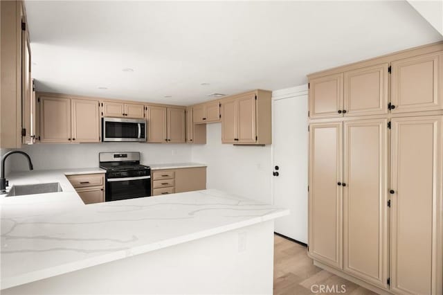516 Sefton Ave Unit A, Monterey Park, CA 91755 - kitchen featuring stainless steel appliances, cream cabinets, light stone counters, a peninsula, and light wood finished floors