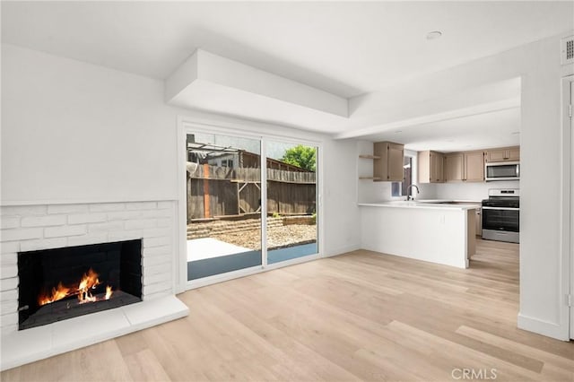 516 Sefton Ave Unit A, Monterey Park, CA 91755 - unfurnished living room featuring a brick fireplace and light wood-style floors