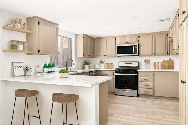 516 Sefton Ave Unit A, Monterey Park, CA 91755 - kitchen with appliances with stainless steel finishes, a peninsula, open shelves, a kitchen breakfast bar, and light wood-type flooring