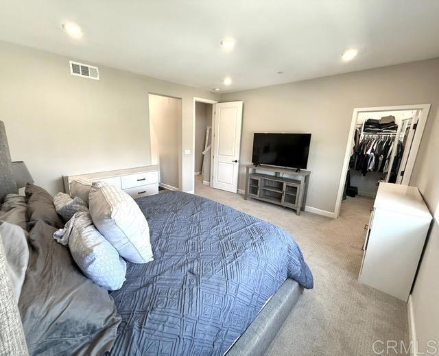 1959 Minimalist Ln, Chula Vista, CA 91915 - bedroom with light carpet, a walk in closet, recessed lighting, and a closet