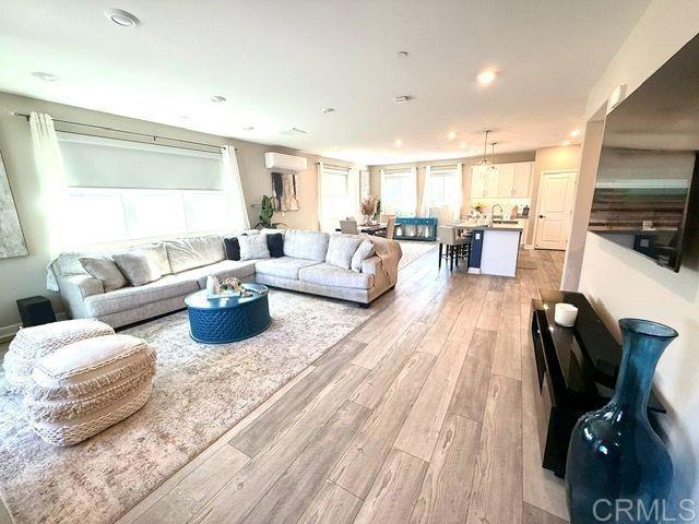 1959 Minimalist Ln, Chula Vista, CA 91915 - living room with light wood-style flooring, a wall unit AC, and recessed lighting