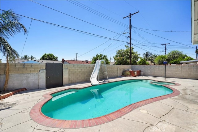 10265 Lev Ave, Arleta, CA 91331 - view of swimming pool featuring a water slide, a fenced backyard, a patio, and a pool with connected hot tub