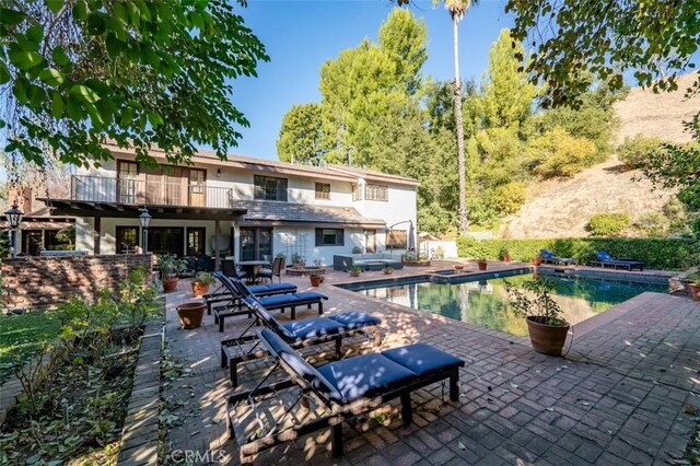 5250 Scott Robertson Rd, Hidden Hills, CA 91302 - rear view of house featuring a patio area, an outdoor pool, a balcony, and stucco siding