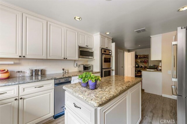 5250 Scott Robertson Rd, Hidden Hills, CA 91302 - kitchen with stainless steel appliances, a kitchen island, tasteful backsplash, light wood finished floors, and recessed lighting