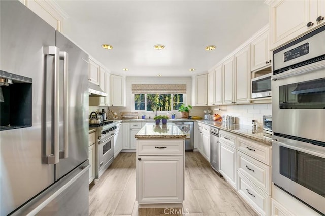 5250 Scott Robertson Rd, Hidden Hills, CA 91302 - kitchen featuring premium appliances, under cabinet range hood, a center island, light stone countertops, and tasteful backsplash