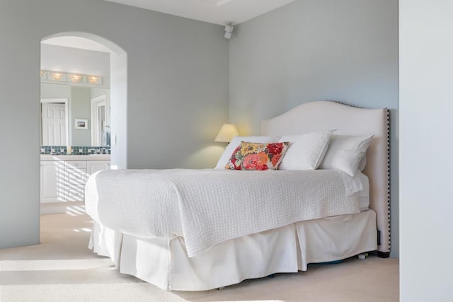 7243 Surfbird Cir, Carlsbad, CA 92011 - bedroom featuring carpet floors, arched walkways, and connected bathroom