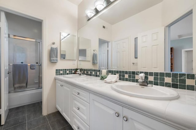 7243 Surfbird Cir, Carlsbad, CA 92011 - bathroom with double vanity, combined bath / shower with glass door, tile patterned floors, and decorative backsplash