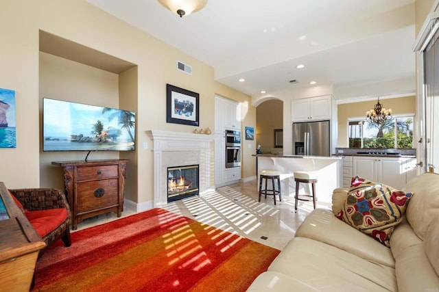 7243 Surfbird Cir, Carlsbad, CA 92011 - living area featuring a chandelier, arched walkways, recessed lighting, and a glass covered fireplace