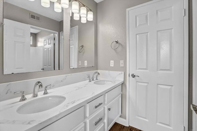 10292 Wateridge Cir Unit 253, San Diego, CA 92121 - bathroom with double vanity, a textured wall, and wood finished floors