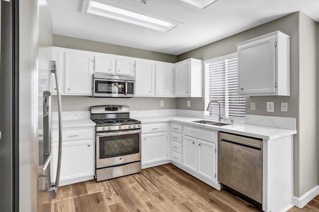 10292 Wateridge Cir Unit 253, San Diego, CA 92121 - kitchen with stainless steel appliances, white cabinetry, light wood-style floors, and light stone countertops