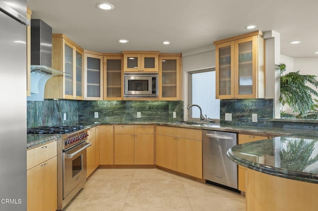 3629 Ocean Dr, Oxnard, CA 93035 - kitchen featuring stainless steel appliances, wall chimney range hood, dark stone counters, glass insert cabinets, and tasteful backsplash