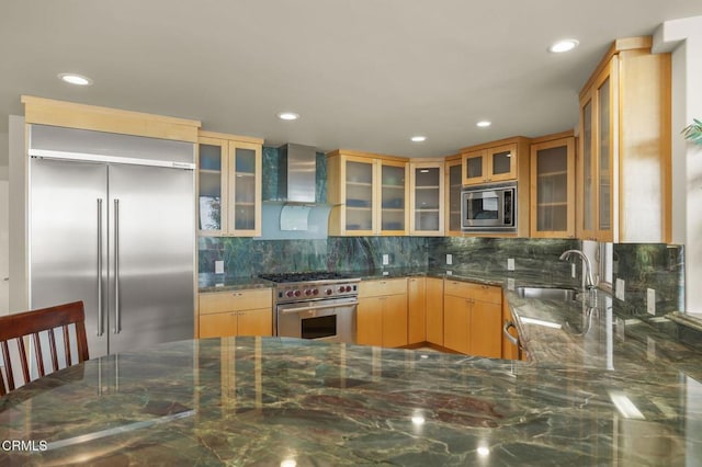 3629 Ocean Dr, Oxnard, CA 93035 - kitchen featuring built in appliances, wall chimney exhaust hood, dark stone countertops, recessed lighting, and decorative backsplash
