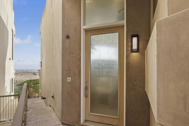 3629 Ocean Dr, Oxnard, CA 93035 - view of exterior entry featuring a water view, stucco siding, and a balcony