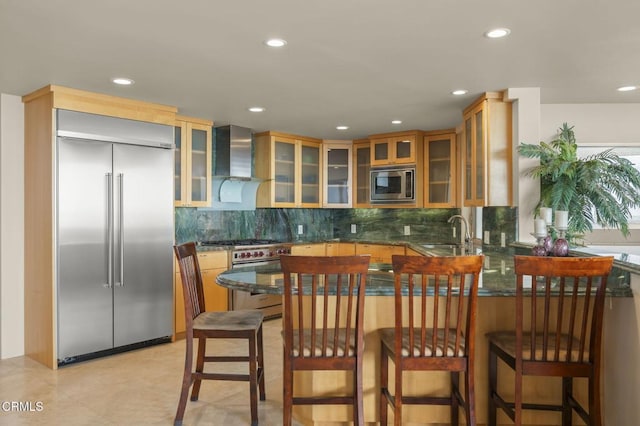 3629 Ocean Dr, Oxnard, CA 93035 - kitchen with built in appliances, wall chimney range hood, a peninsula, decorative backsplash, and recessed lighting