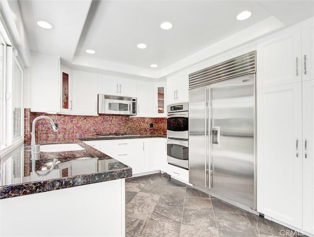 20472 Via Marwah, Yorba Linda, CA 92886 - kitchen featuring stainless steel appliances, a tray ceiling, dark stone counters, white cabinets, and recessed lighting