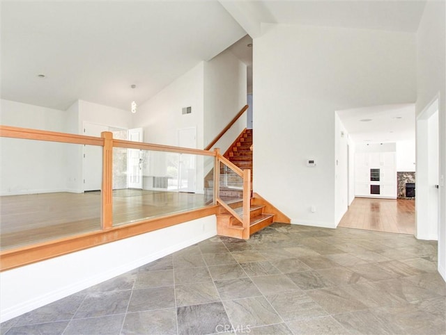 20472 Via Marwah, Yorba Linda, CA 92886 - staircase featuring high vaulted ceiling, a stone fireplace, and stone finish flooring