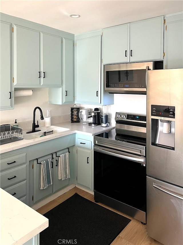 3407 Huxley St Unit 39, Los Angeles, CA 90027 - kitchen featuring appliances with stainless steel finishes, light countertops, and wood finished floors