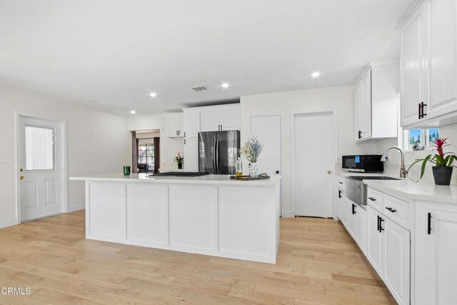 2165 W 115th St, Hawthorne, CA 90250 - kitchen featuring freestanding refrigerator, a kitchen island, white cabinets, light countertops, and healthy amount of natural light