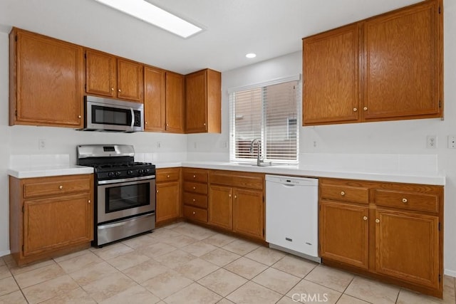 5185 Konic Ct, Riverside, CA 92509 - kitchen with stainless steel appliances, brown cabinetry, light countertops, light tile patterned floors, and recessed lighting