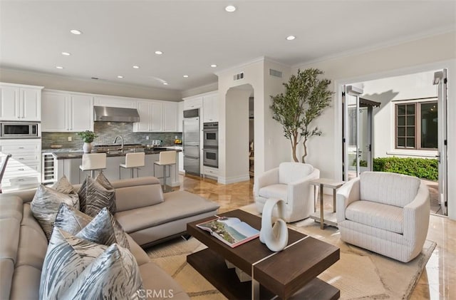 3 Atlantis Cv, Newport Coast, CA 92657 - living room with crown molding, recessed lighting, arched walkways, and wine cooler
