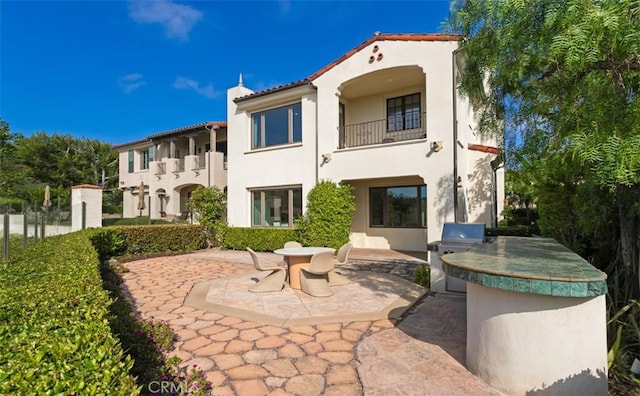3 Atlantis Cv, Newport Coast, CA 92657 - back of property with a balcony, exterior kitchen, stucco siding, and a patio