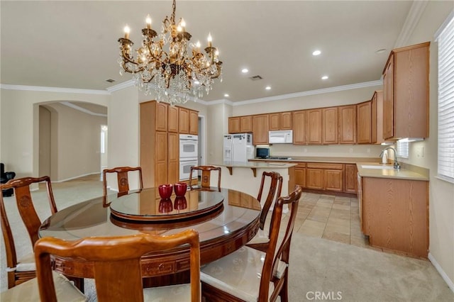 1708 Snowberry Rd, Beaumont, CA 92223 - dining space with arched walkways, light colored carpet, a chandelier, recessed lighting, and crown molding